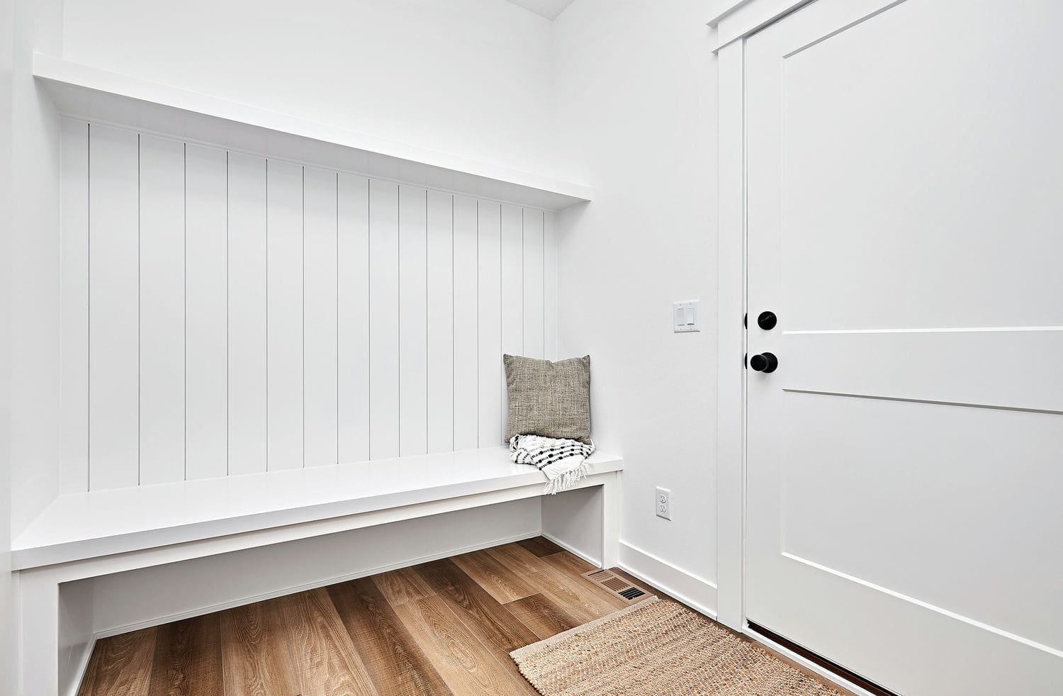 custom built-in entryway bench and wall paneling installed with finishing carpentry