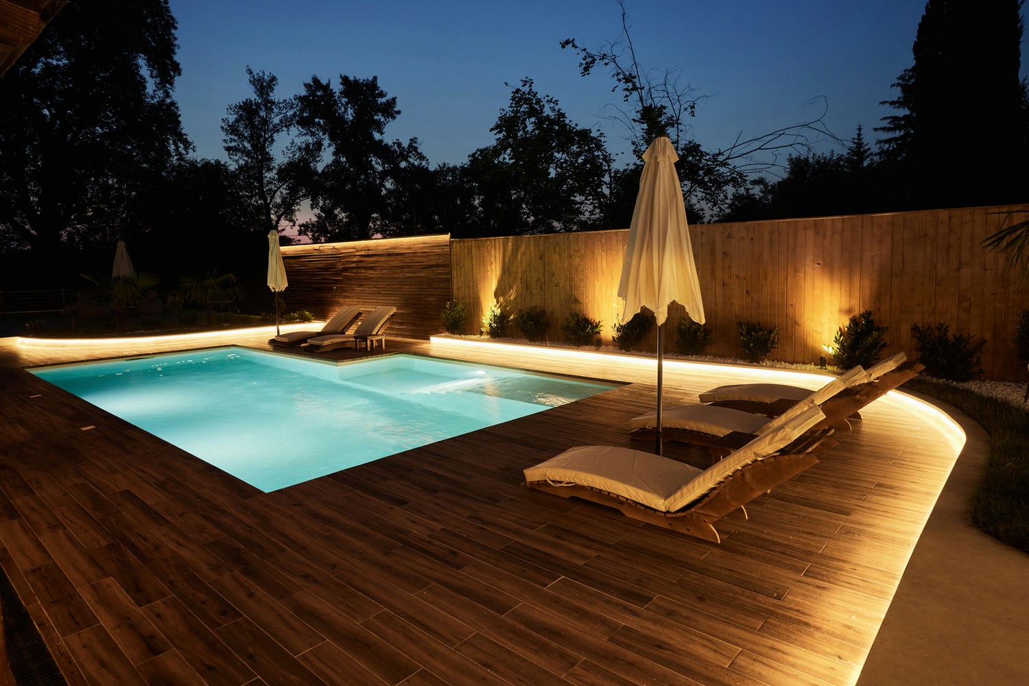 illuminated poolside deck built with exterior carpentry structure