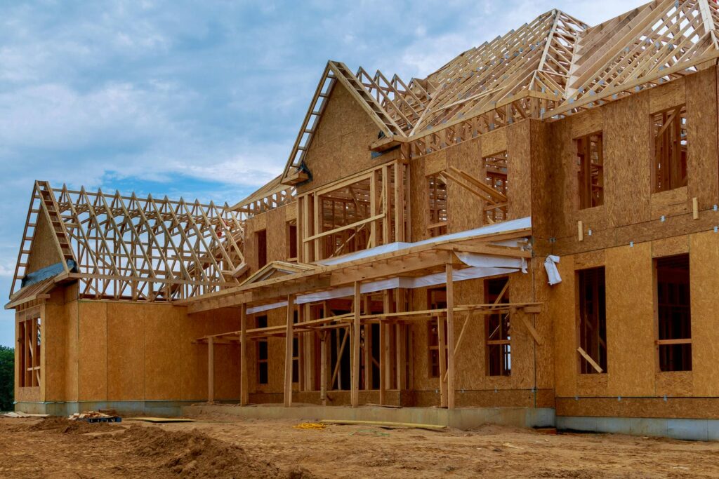 Wood-framed custom home under construction in BC showing the structural framing package shaped by seismic design