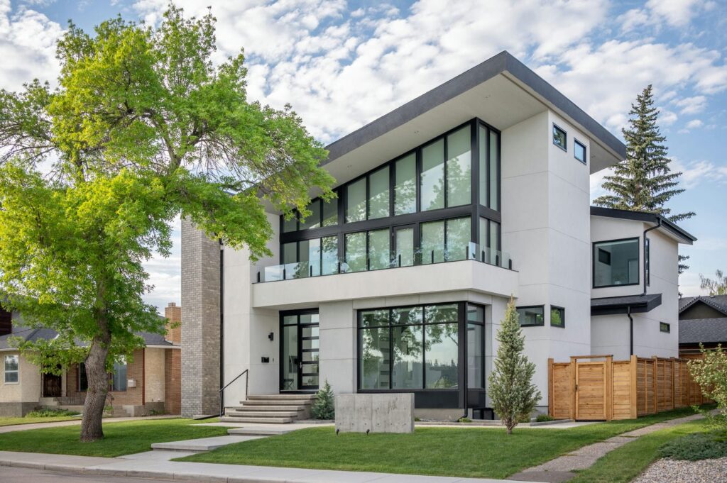 Completed two-story modern home featuring stucco siding, oversized window assemblies, and clean exterior trim details.