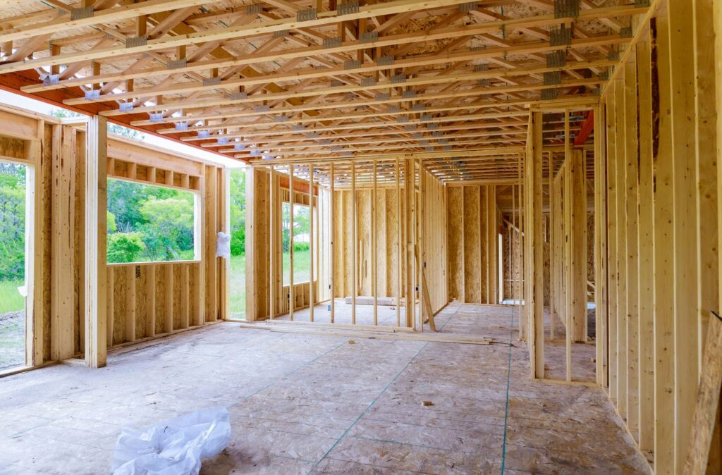Interior custom home framing with chalk layout lines snapped on the subfloor representing accurate framing practice that reduces out-of-square risk