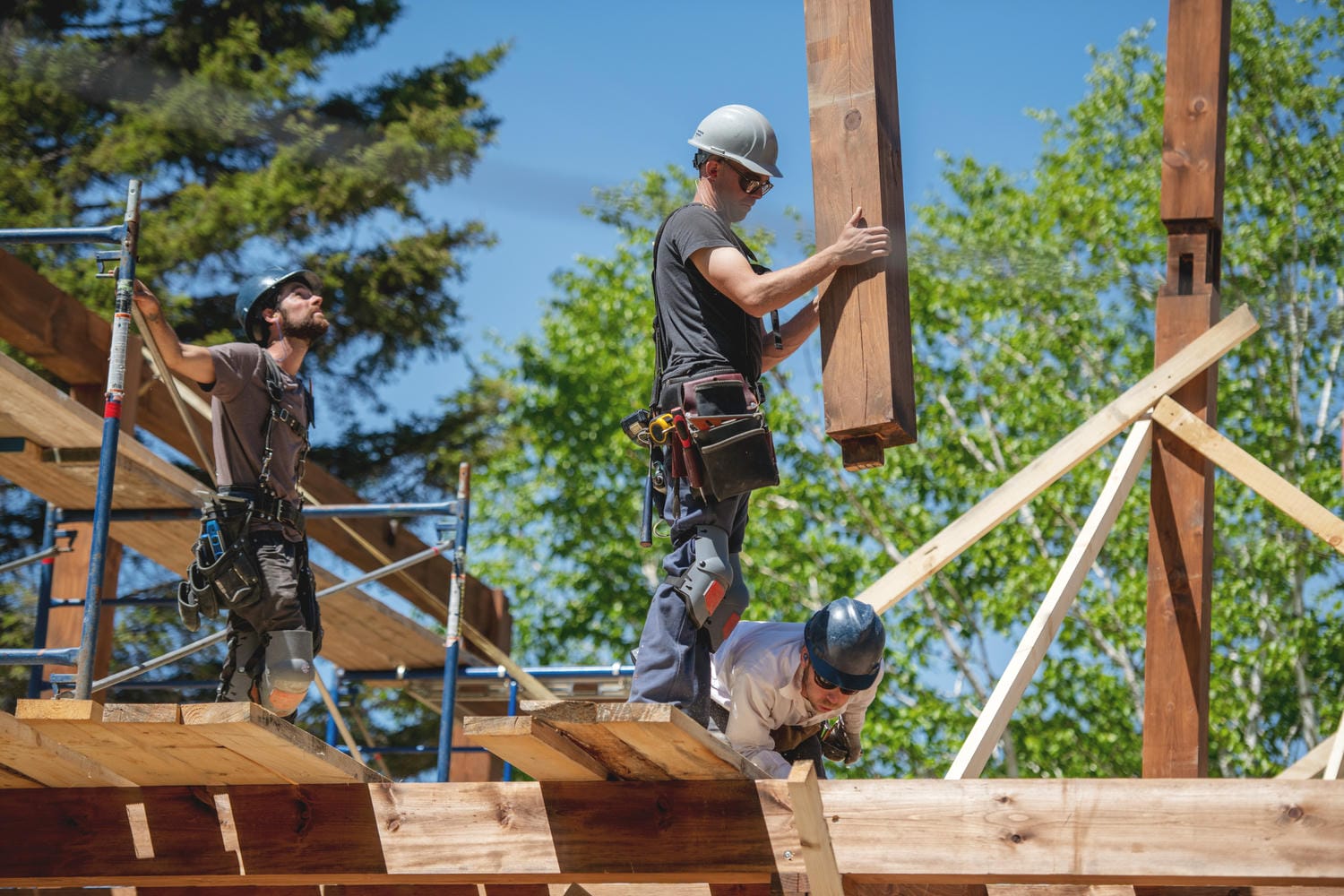 Framing crew setting a long engineered LVL beam over an open main floor in a Lower Mainland custom home.