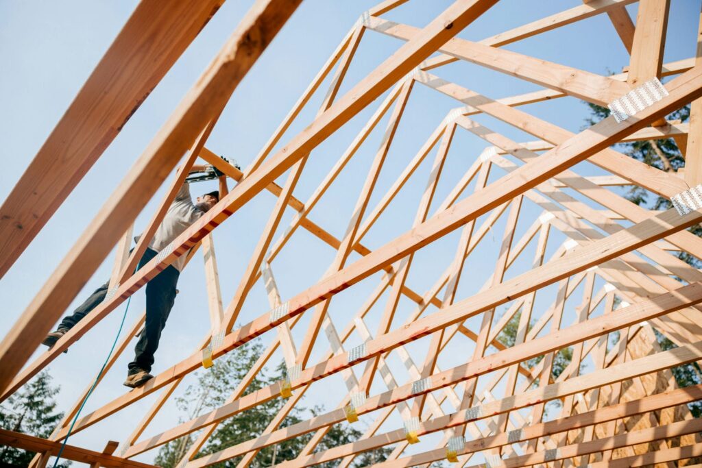 Framer installing pre-engineered roof trusses on a stick-built custom home in the Lower Mainland