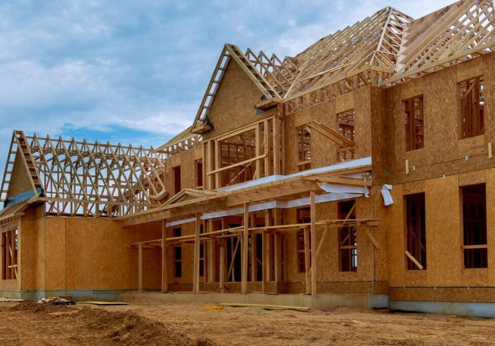 Wood-framed custom home under construction in BC showing the structural framing package shaped by seismic design