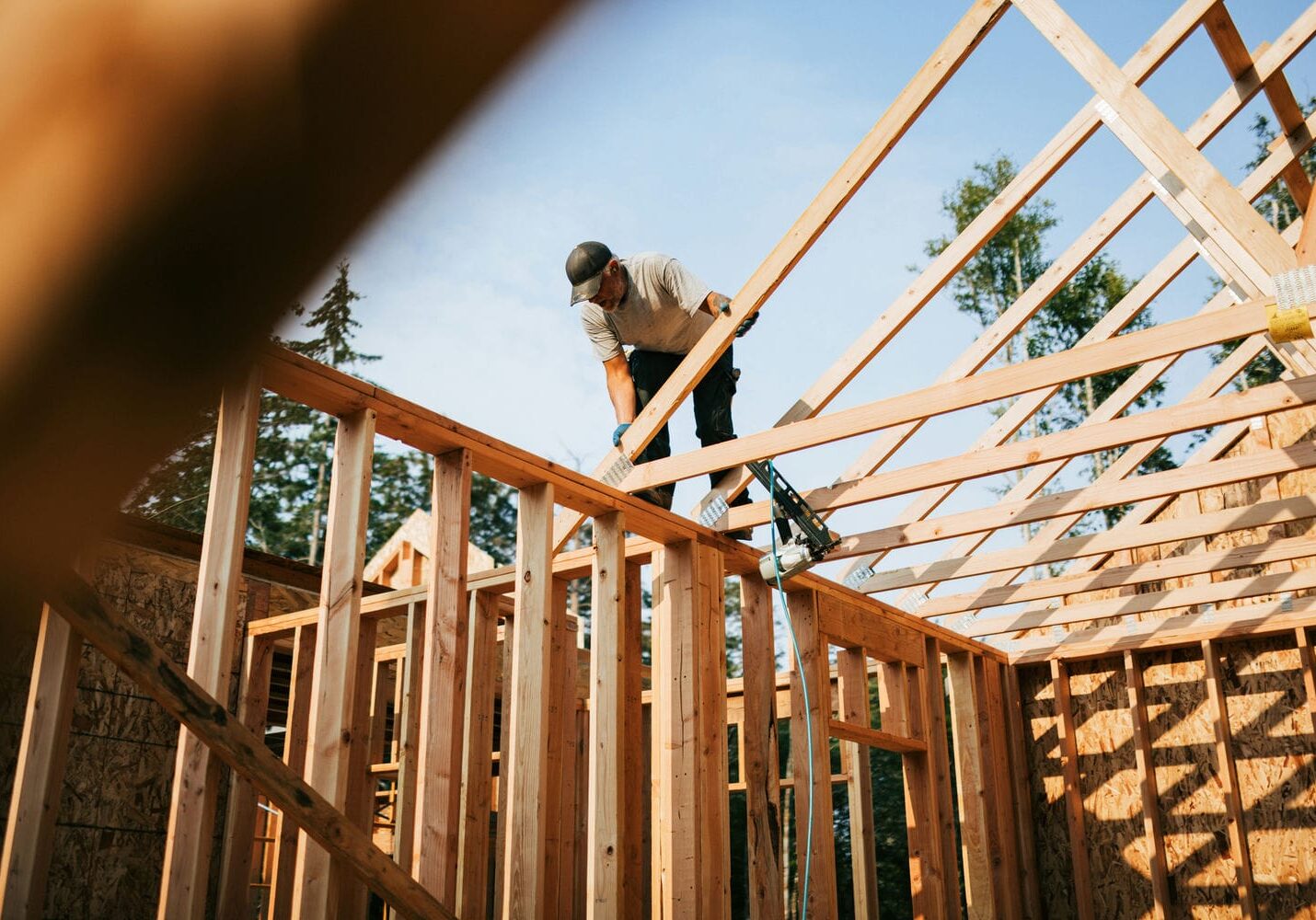 carpenter installing roof framing structure during residential construction